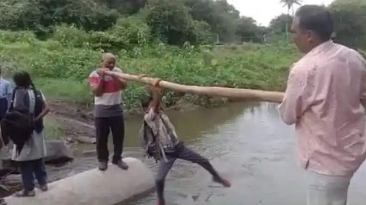 students crossing the river by hanging